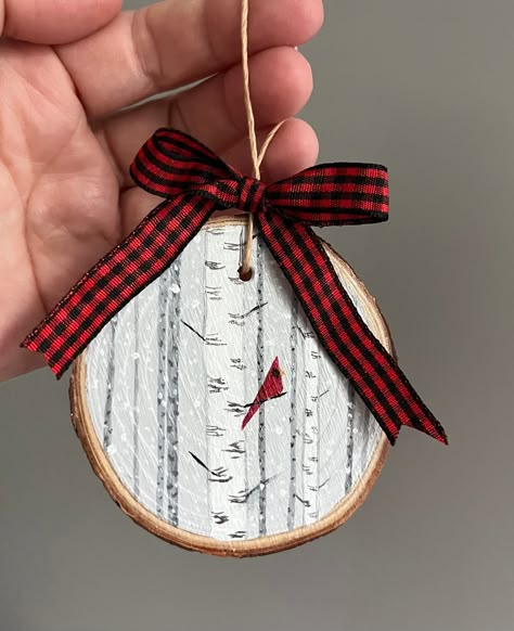 This cheery red cardinal sitting on a branch among birch trees in the snow was hand painted on a live edge slice of pine wood. Perfect for bird and nature lovers to hang on their Christmas tree! Because these are hand painted, no two paintings are exactly alike. The ornament you get may vary slightly from photos.  Dimensions: Vary between 2.75 and 3.5 inches diameter 1/2 inch thick Materials: Live edge pine wood slice Acrylic paint Acrylic varnish Twine Ribbon Shipping: Ready to ship for free wi Christmas Tree Wood Slice Ornament, Painted Wooden Slice Ornaments, Sliced Wood Christmas Ornaments, Painting On Live Edge Wood, Hand Painted Cardinal Ornaments, Woodburned Ornaments Tree Slices, Birch Slice Ornaments, Painting Wood Slices Christmas, Painting Wood Rounds Christmas