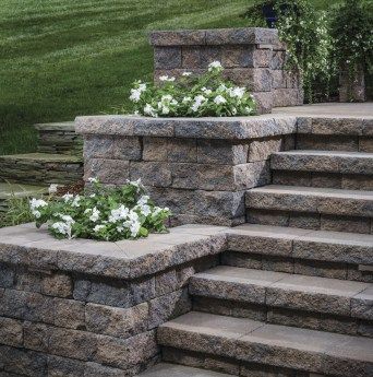 Stair or step planters can take a variety of shapes and styles. Options can include symmetrical tiers, terraced landings, or a singular accent planter. #planter Front Porch Stone Steps, Front Porch Stone, Backyard Retaining Walls, Patio Stairs, Front Door Steps, Front Porch Steps, Landscape Stairs, Patio Steps, Stone Steps