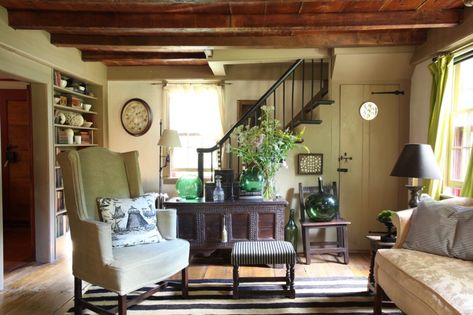 Annie Kelly used a mix of contemporary and period pieces to furnish this 18th-century cottage in Litchfield, Connecticut. In the living room, a 19th-century American stool, an 18th-century sofa and a 17th-century chest sit alongside a wingback armchair by Kelly and a striped jute rug. New England Interior, American Farmhouse Style, American Farmhouse, Into The West, Country Cottage Decor, Stair Case, Cottage Living Rooms, New England Homes, Comfortable Furniture