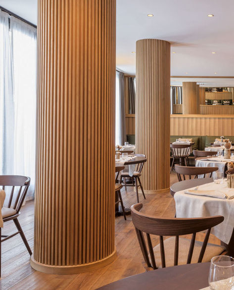 The columns in this modern restaurant's dining room have been wrapped in wood slats, hiding the column within, and turning a potential eyesore into a custom design accent. #RestaurantDesign #Columns #InteriorDesign Round Column Design, Interior Column Design, Column Design Interior, Pillar Design Interior, Column Decoration Ideas, Interior Pillars, Column Decor, Columns Interior, Column Cladding