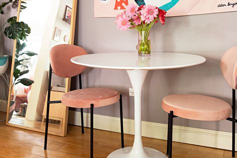 Dining nook with small white tulip table, 2 pink chairs with black legs wood floor, vase of pink and red flowers, full length mirror on floor White Tulip Dining Table, Round Pedestal Dining Table And Chairs, Tulip Dining Table And Chairs, Tulip Table Styling, Tulip Table Dining Room, Tulip Table Decor, Small White Dining Table, White Tulip Table, Minneapolis Apartment