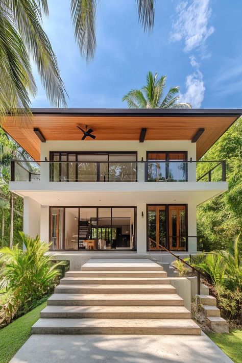 A sleek, modern house with tropical vibes surrounded by lush greenery. Here’s how tropical minimalist houses blend simplicity with vacation vibes, effortlessly creating that paradise-found feeling right at home. High Ceiling Tropical House, Modern Minimalist Beach House, Modern Indonesian House, Modern Tropical House Facade, Modern Tropical House Exterior, Caribbean House Design, Nicaragua House, Asian Modern House, Tropical Minimalist House