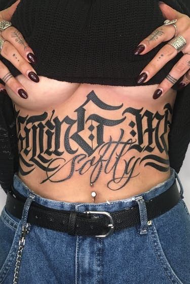 Large Black gothic underboob/ sternum tattoo that says killing me softly. Sternum Lettering Tattoo, Sternum Script Tattoo, Stomach Script Tattoo, Sternum Tattoo Large, Gothic Sternum Tattoo, Butterfly Neck Tattoo, Stomach Tattoos Women, Belly Tattoos, Tattoo Shading