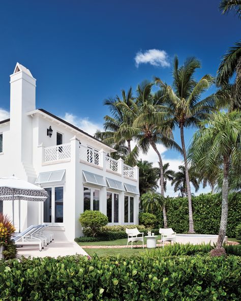 The team splashed the home’s façade in Benjamin Moore’s Vanilla Milkshake and added shutters in Sherwin-Williams’ Niebla Azul. The back exterior’s umbrellas and furnishings are by Janus et Cie, including chaise lounges with Perennials fabric cushions. West Indies House, Coastal Home Exterior, Bahama Shutters, Beach House Tour, Janus Et Cie, Vanilla Milkshake, Architecture Home, Luxurious Home, Coastal Retreat