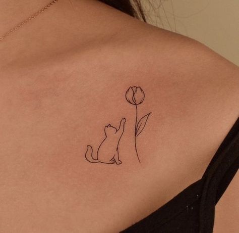 Uncover the meanings behind cat tattoos across cultures and beliefs. Learn about fascinating symbolism as well as the best ideas for inspiration. Cat Inspired Tattoos Simple, Cat Memorial Tattoo Minimalist, Fine Line Cat Tattoo With Flowers, Minimal Tattoo Cat, Cat With Flowers Tattoo, Fineline Cat Tattoo, Cat And Flower Tattoo, Flower Cat Tattoo, Cat Fine Line Tattoo