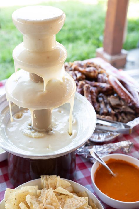 With a few simple tweaks, you can transform your chocolate fountain into a nacho cheese fountain, perfect for your next party or game day celebration. Imagine the look on your guests' faces as they dip chips, pretzels, and veggies into a cascading fountain of warm, velvety cheese. In this blog post, we'll guide you through the steps to create your very own nacho cheese fountain, turning an ordinary gathering into an unforgettable cheesy extravaganza. Cheese Dip Fountain Wedding, Cheese Fondue Fountain, Queso Fountain Recipe, Queso Dip Fountain Wedding, Cheese Fountain Wedding, Nacho Fountain Bar, Cheese Fountain Recipe, Queso Fountain, Cheese Fondue Charcuterie Board