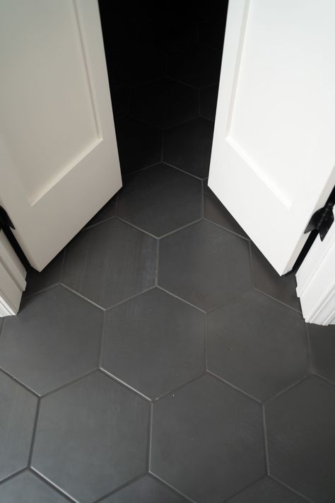 Black Hexagon Tile Floor Laundry Room, Black Tile Guest Bathroom, Charcoal Gray Bathroom Floor, Black Hexagon Tile Black Grout, Black Hexagon Tile Bathroom Floor With Wood Vanity, Black Hex Floor Tile, Black Hexagon Tile Grout Color, Grey Honeycomb Tile Bathroom, Black Octagon Tile Bathroom Floor