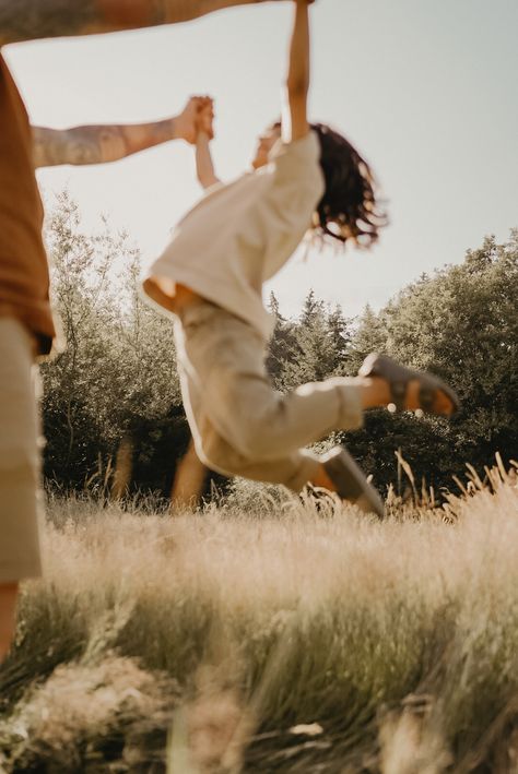 Father holding son’s hands while son jumps in the air Fall Lifestyle Photography, Family Film Photography, Film Family Photography, Family Park Photoshoot, Outdoor Family Photoshoot, Documentary Family Photography, Family Park, Photo Documentary, Outdoor Family Photography