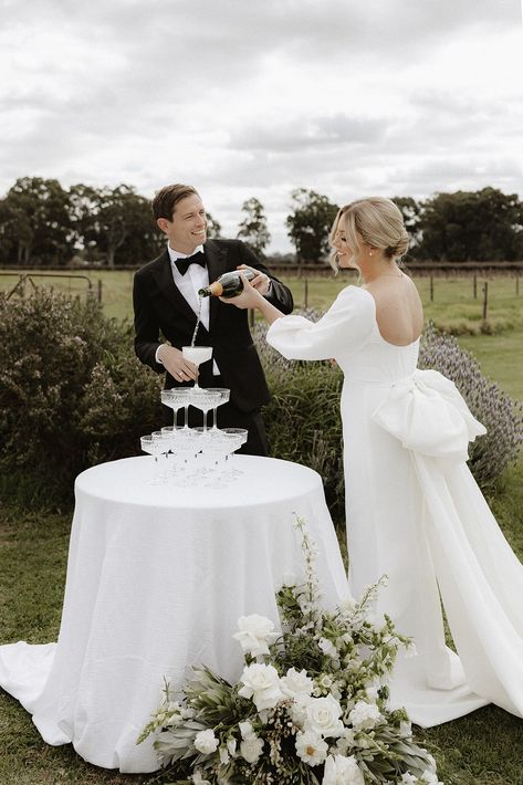 Small Champagne Tower Wedding, Diy Champagne Tower, Minimalist White Wedding Cake, Cake And Champagne Table, Mini Champagne Tower, Hailey Bieber Wedding, Champagne Tower Wedding, Elegant Wedding Themes, Champagne Tower