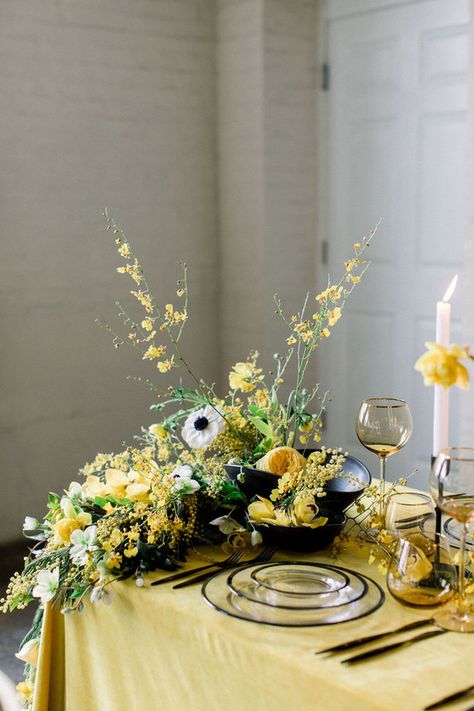 The tablescape was done with a yellow tablecloth, lush white and yellow blooms and greenery, black porcelain and sheer plates. White Spring Wedding, Green Spring Wedding, Gold Winter Wedding, Yellow Tablecloth, Tablescape Wedding, Spring Wedding Ideas, Yellow Wedding Theme, Spring Entertaining, Cake Table Decorations