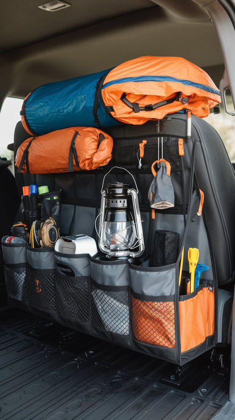 Back-of-seat organizer filled with camping gear, including sleeping bags, a lantern, and various outdoor essentials, neatly arranged in a truck for efficient space management. Truck Camping Hacks, Suv Camping Hacks, Pick Up Truck Camping, Car Camping Ideas, Truck Camping Setup, 4runner Camping, Vehicle Organization, Car Camping Hacks, Car Camping Organization