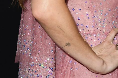 Dakota Johnson's 12 tattoos and their meanings, explained Dakota Johnson Tattoo, Tiny Cross Tattoo, Tattoos And Their Meanings, Dainty Tattoo, 12 Tattoos, Bicep Tattoo, Stick N Poke Tattoo, Poke Tattoo, Matching Tattoo