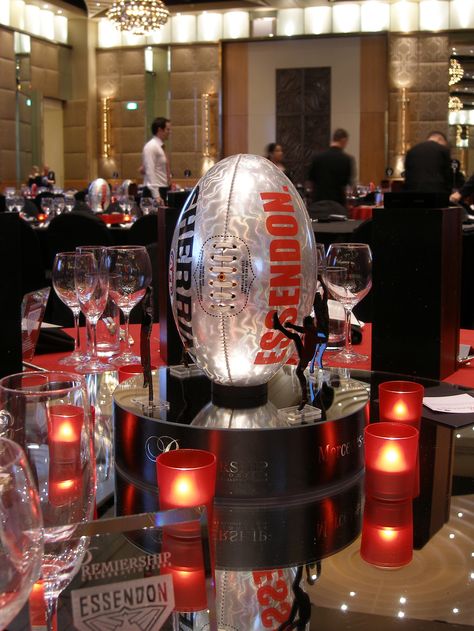 Footy themed centerpiece on a mirror base surrounded by red tea lights Football Banquet Centerpieces, Dallas Cowboys Theme, Football Centerpieces, Sports Centerpieces, Banquet Centerpieces, Football Banquet, 21st Ideas, Bat Mitzvah Themes, Mitzvah Decor