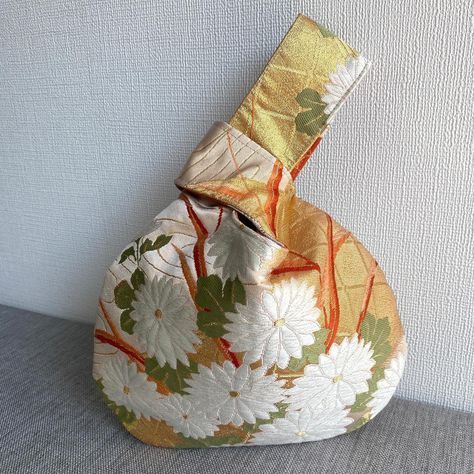 Reversible obi knot bag🧡 The gold fabric with white chrysanthemum flower pattern makes this elegant and luxurious obi fabric into a "shijimi bag"💛 This shape is called a Knot Bag in English... | Instagram White Chrysanthemum Flower, Japanese Knot, Japanese Knot Bag, White Chrysanthemum, Knot Bag, Plum Blossoms, Chrysanthemum Flower, Japanese Silk, Kimono Fabric