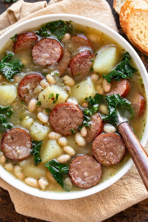 This sausage soup is rich and cozy, brimming with hearty ingredients such as beef smoked sausage, diced potatoes, white beans and kale! | thecozyapron.com #sausagesoup #sausagesouprecipes #sausagesouphealthy White Bean And Sausage Soup, White Bean Sausage Soup, Beef Smoked Sausage, White Bean And Sausage, Beans And Kale, Kale White Bean, Soup Sunday, Bean And Sausage Soup, Pasti Fit