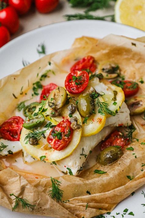 Baked Cod in Parchment Paper is all about the 3 f’s: fresh, flavorful, flaky! Cooked low and slow, it yields tender fish topped with sliced lemon, tomatoes, capers, olives, and fresh herbs. The best part is that it takes just 30 minutes to make! This baked Mediterranean cod recipe is a delightful addition to your weeknight dinner rotation. It's topped with fresh ingredients then steamed in parchment paper, a method known as en papillote in French and al cartoccio in Italian. Roasted Chicken Thighs And Vegetables, Cod In Parchment, Mediterranean Cod, Miso Salmon Recipe, Pistachio Crusted Salmon, Sliced Lemon, Miso Glazed Salmon, Cod Recipe, Dinner Rotation