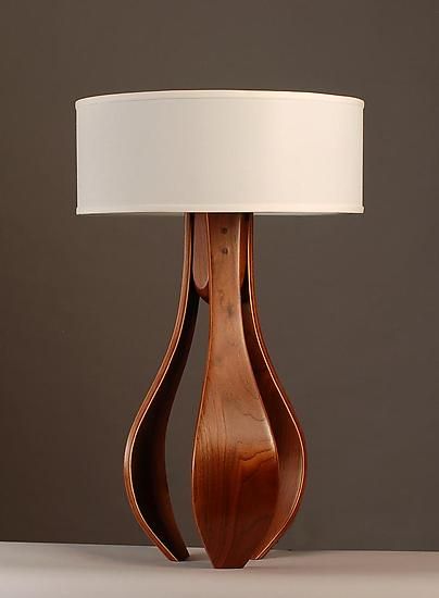 Chloe in Walnut with White Shade by Kyle Dallman. An elegant, harmonious design handcrafted from walnut wood. Three gently curving legs, created using the bent lamination technique, are given a hand-rubbed oil and varnish finish that accentuates the warmth and beauty of the wood grain. Topped with a simple white shade. Dimming fixture uses one 100-watt max. bulb (not included). Interesting Lamps, Wooden Work, Tree Bookshelf, Wood Table Lamp, Table Lamp Wood, Decorative Lighting, Table Lamp Design, Wooden Lamp, Room Lighting