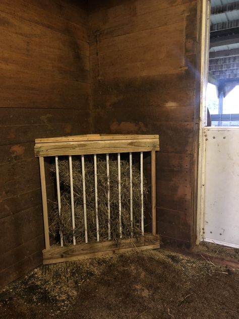 Custom made hay feeder. Flexible PVC pipes that will break under presure (for safety) set 4.5” apart. Floor is slanted to ensure hay falls down to front of feeder and feeder is set at ground level to encourage natural grazing position. Top slides in to avoid the use of hardware. Diy Horse Stall Hay Feeders, Pony Hay Feeder, Horse Stall Feeder Ideas, Horse Stall Hay Feeders, Diy Hay Feeder For Horses, Corner Hay Feeder, Diy Covered Hay Feeder For Horses, Stall Hay Feeder For Horses, Corner Hay Feeder For Horses