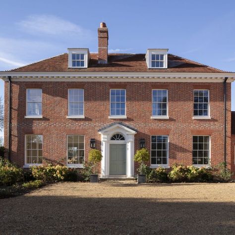 On a beautiful site next to the church in a small Hampshire village, this new house is designed in the tradition of local manor houses. The main part of the house has a square plan and is built in a soft red brick, with a painted timber cornice and a reclaimed tile roof. Read more about the project, designed by George Saumarez Smith on the ADAM Architecture website. #house #home #manor #classic #symmetry #doorcase #traditional #architecture #dreamhouse #coutrylife #countryliving #countryside Georgian House Uk, Manor House Plans, Adam Architecture, Suffolk House, Architecture Website, Georgian Style Homes, Country Modern Home, Hampshire Uk, Country House Design