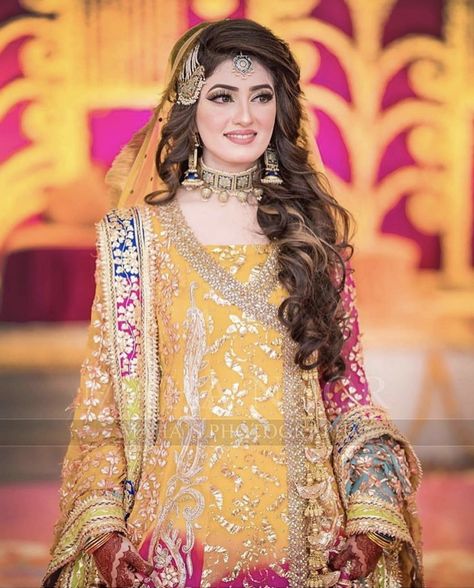 A stunning muslim bride in a multicolor outfit for her mehendi with gota jaal work and gota borders paired with an offbeat blue enamel statement choker and jhoomar with a tiny simple maang tika - photography by mahasphotographyofficial | #muslimbride #weddinghairstyle #weddinginspiration #wittyvows #multicolor #bridallook #bridegoals #henna #pakistaniwedding #bridalmakeup #bridaljewelry #bridalphotography #jhumar #weddinghairstyles #weddingphotography #maangtika #yellow #curls Pakistani Bride Hairstyle, Haldi Makeup, Pakistani Bridal Hairstyles, Hairstyles Pakistani, Bridal Mehndi Dresses, Pakistani Bridal Makeup, Shadi Dresses, Mehendi Outfits, Asian Bridal Dresses