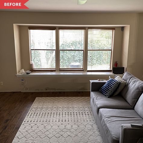 Gray couch in front of large window with cream-colored area rug Alternative Apartment, Living Room Window Seat, Playroom Apartment, Shelving Hacks, Rental Upgrades, Cabinet Hacks, Table Apartment, Wide Kitchen, Storage Apartment