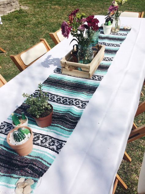 This is a simple yet fun way to put together a southwestern baby shower table using a blanket cut as a table runner! #babyshower #southwestern #mexicanblanket Southwestern Theme Party, Southwestern Party Decor, Mexican Theme Baby Shower Ideas For Boy, Southwest Baby Shower Ideas, Aztec Baby Shower Ideas, Southwestern Baby Shower Ideas, Boho Western Baby Shower Ideas, Southwest Baby Shower, Southwestern Baby Shower