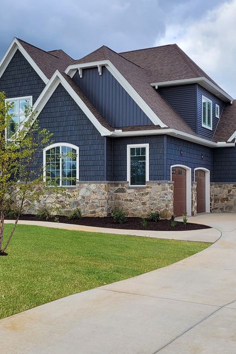 This Craftsman Cottage features our Silver Patina Webwall on the exterior. The earth and shadow tones of this natural stone complement the deep blue siding color of the house leaving a beautiful masterpiece. Navy Blue House Exterior White Trim Brown Roof, Homes With Blue Siding, Deep Blue Siding House, Dark Navy Siding Exterior, Navy House With White Trim, Navy Blue Siding With Brick, Exterior Two Tone House Colors, Navy And Stone House Exterior, Dark Blue Siding House With Stone