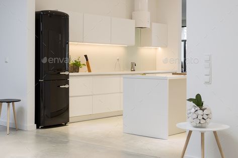 White kitchen with black fridge by bialasiewicz. Minimalistic kitchen interior with white furniture and a black modernist fridge#fridge, #bialasiewicz, #black, #White Expensive Fridge, Kitchen With Black Fridge, No Window Kitchen, Luxurious Minimalism, Modern Konyhatervezés, Black Fridge, Minimalistic Kitchen, Black Fridges, Black Appliances Kitchen