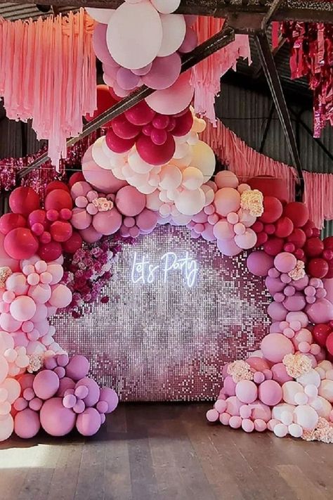 Bring glitz & glam to the party decor by setting up a fabulous backdrop and make your guests WOW. Exude a rejuvenating vibe by designing a ritzy backdrop using blush sequin wall with “Let’s Party” light sign and add extra pizzazz by pepping it with a fuchsia, pink, & blush balloon garland and insert blush wisteria vines for a striking display. Create a vibrant ceiling decor by hanging fuchsia fringe foil curtains along with blush paper streamers and make your party look aesthetically attractive. Blush Balloon Garland, 15th Birthday Decorations, Unique Event Decor, Wisteria Vines, Pink Event, Butterfly Centerpieces, Balloons Galore, Sequin Wall, Pink Birthday Party