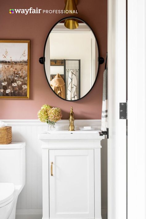 Can’t get enough of autumn? @sabrinaoneilldesign’s clients felt the same way, so she made simple yet impactful updates to give their bathroom all the fall feels. The designer began by painting the walls a comforting, rich rose and adding traditional wainscotting. A petite vanity with brass hardware, a pivoting metal mirror, and a print depicting a country field completed the look. Drop a 🍁 if you love it too! Photography: Janet Kwan. Styling: Emily-Bazett Jones. Mauve Bathroom, Modern Wainscoting Ideas, Pink Powder Room, Dining Room Images, Wainscoting Bathroom, White Wainscoting, Living Room Images, Dining Room Blue, Wainscoting Panels