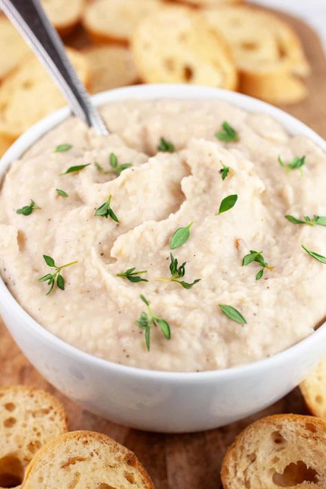 This Italian White Bean Dip makes a great healthy and flavorful appetizer! It's made with canned cannellini beans, garlic, lemon juice, Italian seasoning, and olive oil that's pureed in a food processor until smooth and creamy. This Mediterranean dip is perfect served on some toasted crostini or with some crackers or raw veggies. It's also great as a sandwich spread. This dip is naturally vegan, gluten free, and dairy free. It only takes 5 minutes to prepare and is great for parties! Cannellini Bean Dip, White Bean Dip Recipe, White Bean Spread, Gluten Free Baguette, Mediterranean Dip, Mediterranean Appetizers, Toasted Crostini, Raw Veggies, White Bean Dip