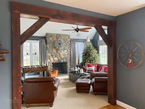 E. Braun reclaimed beams and boards were used to craft this eye-catching archway that makes a picture-perfect frame for the cozy living room and wonderful stone fireplace. www.braunfarmtables.com Rustic Archway Living Rooms, Living Room To Kitchen Archway, Wall Beams Living Room, Accent Column Living Rooms, Archway Living Room, Rustic Beams In Living Room, Farmhouse Archway, Archway To Living Room, Living Room With Archway