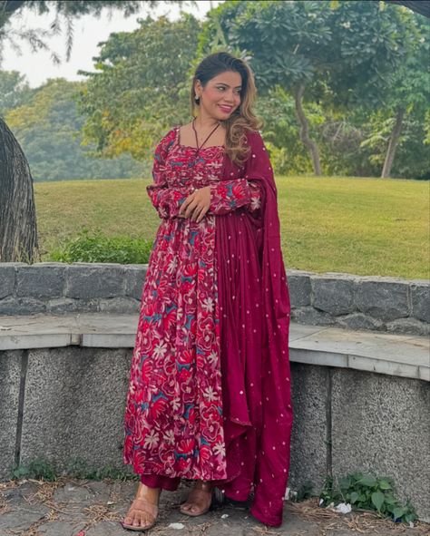 Traditional Indian outfit featuring a long-flowing maroon Anarkali-style dress with floral prints in shades of red, pink, and white. The suit is complemented by a matching maroon dupatta with subtle white polka dots, embroidered giving it an elegant and festive appearance. The material is crepe chiffon comfortable, suitable for occasions like festive gatherings or casual events. • Anarkali suit • Floral print • Maroon and pink tones • Indian ethnic wear • Festive outfit • Matching dupa... Maroon Anarkali, Maroon Dupatta, Outfit Matching, Traditional Indian Outfits, Anarkali Suit, Indian Outfit, Indian Ethnic Wear, Pink Tone, Traditional Indian