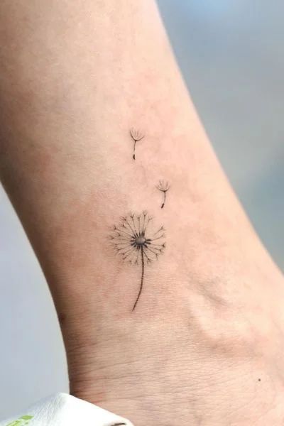 Discovering the Charm of Dandelion Tattoos - Tweakbee Small Tattoo Dandelion, Tiny Dandelion Tattoos For Women, Realistic Dandelion Tattoo, Dandelion Tiny Tattoo, Free Your Mind Tattoo, Tiny Tattoos Dandelion, Dandelion Tattoo Design For Women, Blowing Dandelion Tattoo, Dandelion Child Tattoo