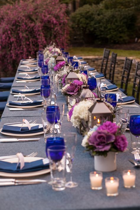 The tablescapes featured navy blue denim tablecloths, hammered highball classes, and cobalt blue goblets. They were topped with shimmering votives, hurricane lanterns, and arrangements of hydrangea, dahlias, thistle, lavender, and dusty miller. |   Photo by Jayd Gardina Photography Purple Wedding Decor, Blue And Purple Wedding, Blue Place Settings, Blue Goblets, Navy Blue And Purple, Denim Wedding, Purple Table, Purple Wedding Theme, Wedding Colors Purple