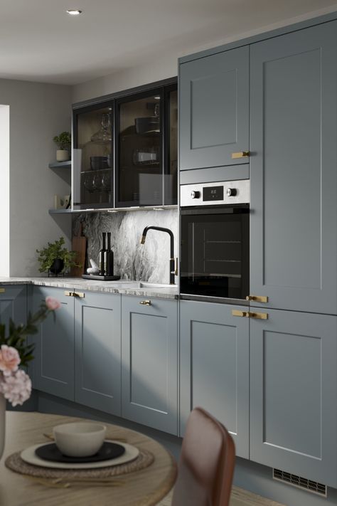 We are loving our new Chelford Dusk Blue Kitchen. Use this stunning traditional kitchen design to inspire your blue kitchen ideas. Use Grey Marble Effect laminate countertops and oak flooring to create a traditional kitchen design with a modern kitchen design feel. Finish with antique brass handles or antique brass kitchen hardware to add the finishing touches to your kitchen hardware. A black kitchen tap and dark glass kitchen cabinets create the perfect mdoern kitchen inspiration. Glass Finish Kitchen Cabinets, Dark Grey Marble Countertops Kitchen, Dusk Blue Kitchen Howdens, Antique Blue Kitchen Cabinets, Greyish Blue Kitchen, Dusky Blue Kitchen, Grey And Blue Kitchen Ideas, Grey Blue Kitchen Cabinets, Grey Oak Kitchen