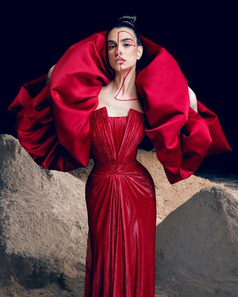 Red pleated lurex gown with a structured neckline- featuring a voluminous satin duchess shoulders cape.. Red Concert, Rami Kadi, Concert Poster Design, Shoulder Cape, Couture Looks, Strong Shoulders, Graduation Project, Concert Poster, Red Outfit