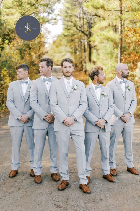 Soft gray suits for this December wedding. The groom stands out with a light gray tie while groomsmen don traditional bowties in light blue matching the bridesmaid dresses. All are wearing matching brown shoes. #graysuits #groomsmeningray #graysuitforgroom #sainteterrewedding #groomstyle #weddingdaysuits #groomsmeninspo #weddingparty Grey Wedding Party Attire, Light Gray Groomsmen Suits, Gray Suits For Men Wedding, Light Blue Groomsmen Suits, Light Gray Groomsmen, Light Grey Suits Wedding, Groomsmen Attire Grey, Gray Wedding Party, Light Gray Suit