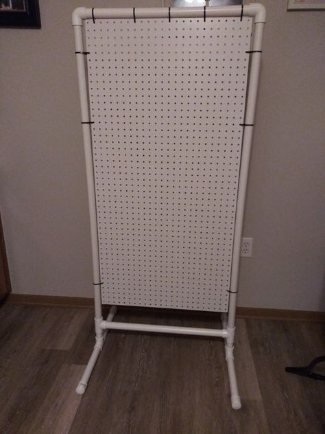 Cost roughly $35 to put together. 2x4 pegboard, pvc pipe, pvc t's, pvc elbows and zip ties is all you need to recreate this. Free Standing Pegboard Display Diy, Pvc Organization Ideas, Pvc Vendor Display, Craft Booth Pegboard Display, Peg Board Display Stand, Pegboard Store Display, Craft Fair Pegboard Display, Tier Display Stand Diy, Room Divider Repurpose