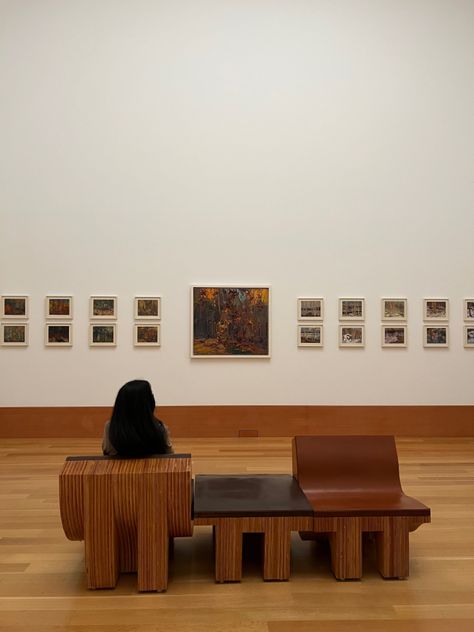 A girl sitting down at an art gallery, staring at wall art that depicts nature and the different seasons Art Gallery Seating, Art Gallery Furniture, Gallery Bench, Museum Bench, Gallery Furniture, Cultural Centre, Wooden Bench, Coworking Space, Art Galleries