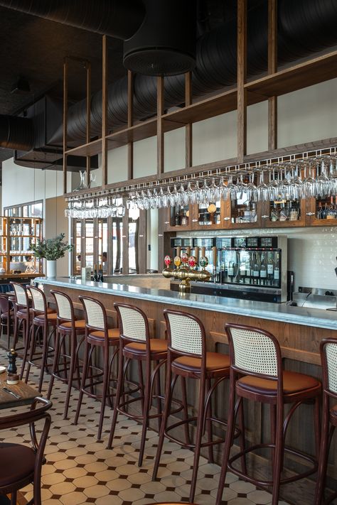 Bistro Le Bleu in Aarhus, Denmark has an airy and light interior design with large windows and a high ceiling. To ensure the bistro’s good acoustic qualities, black Troldtekt acoustic panels were chosen for the entire ceiling to camouflage the black-painted ventilation pipes and similar installations. #goodacoustics #holzwolleplatten #träullsplattor #woodwoolpanels #troldtekt | Architects: SLETH Light Interior Design, Dark Wooden Furniture, Acoustics Design, Bistro Interior, Aarhus Denmark, Long Room, Marble Bar, Modern French, French Restaurants