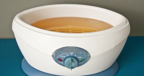 A paraffin bath machine contains a heat source and tank that holds paraffin wax. The machine melts the wax and maintains it in a liquid state. When you immerse your hand, foot or other body part in the liquid paraffin, the wax coats the body part completely. The warm temperature from the wax penetrates the skin, muscles and bones to provide a... Paraffin Bath, Wax Machine, Liquid Paraffin, Scaly Skin, Body Waxing, Heat Therapy, Layers Of Skin, Paraffin Wax, Spa Treatments