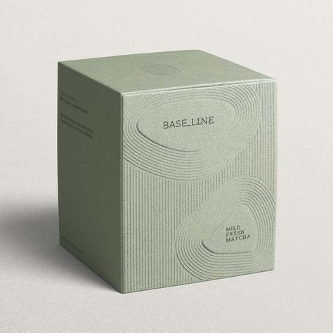 A cardboard soft green tea box with an embossed line pattern inspired by Kyoto gardens. It features the company, Baseline, logo and product description inside a pebble shape. Matcha Packaging, Mises En Page Design Graphique, Visuell Identitet, Luxury Packaging Design, Skincare Branding, Cosmetic Packaging Design, Perfume Packaging, Skincare Packaging, Candle Packaging