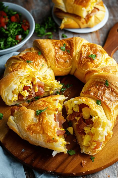 Whip up a Crescent Breakfast Ring for a delightful twist on breakfast! Featuring eggs, bacon, cheese, and crescent rolls, plus a pop of bell peppers, it's the ultimate brunch hero. Easy to make and irresistibly delicious, it's perfect for family gatherings or a special Sunday treat. Don't miss out on making mornings special. Pin this recipe for later and share your breakfast masterpiece with us! Croissant Breakfast Egg, Egg Bacon Crescent Roll, Canned Crescent Roll Recipes Breakfast, Breakfast Crescent Roll Ring, Bacon Egg And Cheese Crescent Rolls, Christmas Breakfast Crescent Roll Wreath, Breakfast Recipe With Crescent Rolls, Crescent Roll Breakfast Recipes Eggs, Ham And Egg Crescent Rolls