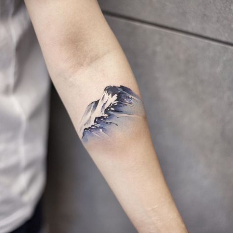 A watercolor snow mountain inked on the left forearm by tattooist Chenjie Snow Mountain Tattoo, Snowy Owl Tattoo, Watercolor Mountains Tattoo, Reflection Tattoo, Wrist Tatoo, Leopard Print Tattoos, Watercolor Snow, Winter Tattoo, Snow Tattoo