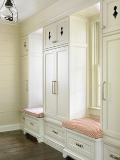 Beautiful cottage mudroom features two built in window seat benches accented with red trellis seat cushions and sat between built in cabinets fitted with aged nickel pulls and accented by cutouts on the top cabinet doors. Cottage Mudroom, Cottage Laundry Room, Built In Window Seat, Window Bench Seat, Window Seat Storage, Window Seats, Build A Closet, Bedroom Closet Design, Beautiful Cottages