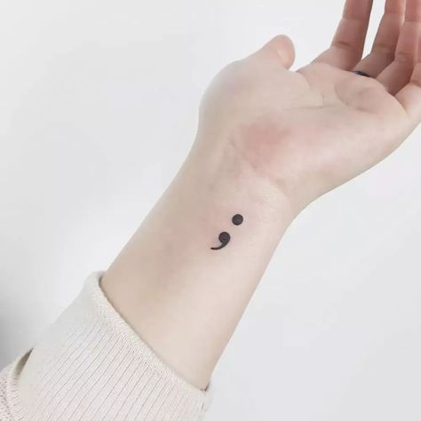 Explore the profound meaning behind a semicolon tattoo—a symbol of hope, resilience, and the continuation of life. 💪 #SemicolonTattoo #TattooArt Embalming Tattoo, Semi Colon Tattoo Wrist, Simple Semicolon Tattoo, Snall Tattoos, Mental Health Symbol, Tats With Meaning, Semi Colon Tattoo, Semicolon Tattoo Meaning, Symbol Tattoos With Meaning