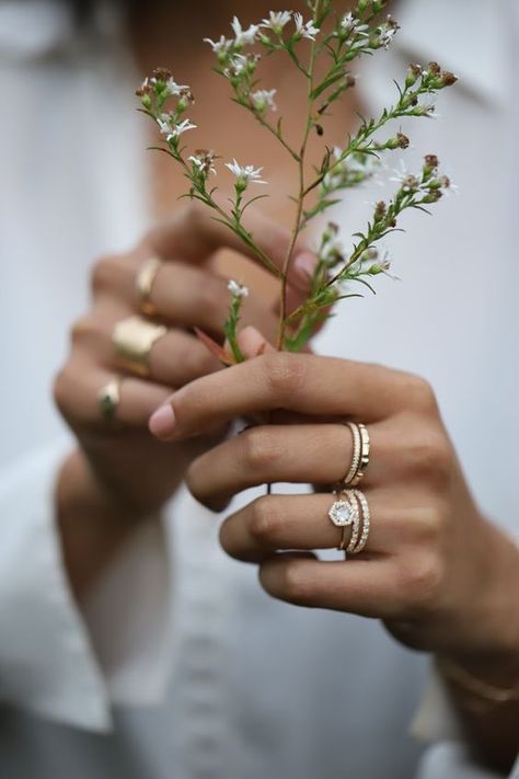 An engagement ring shot at a bridal photoshoot. a simple and dainty diamond bridal stacking ring set with wildflowers and a white blouse Dainty Diamond Engagement Ring, Ring Photoshoot, Jewellery Photography Inspiration, Ring Photography, Jewelry Product Shots, Creative Jewelry Photography, Hand Photography, Jewelry Photography Styling, Jewelry Photoshoot