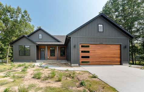 Green House Wood Garage Door, Dark Exterior Siding Ideas, Wood Looking Garage Doors, Dark Gray House Exterior, Grey Siding House, Dark Grey Houses, First House Ideas, Burgundy Color Scheme, Exterior Home Colors