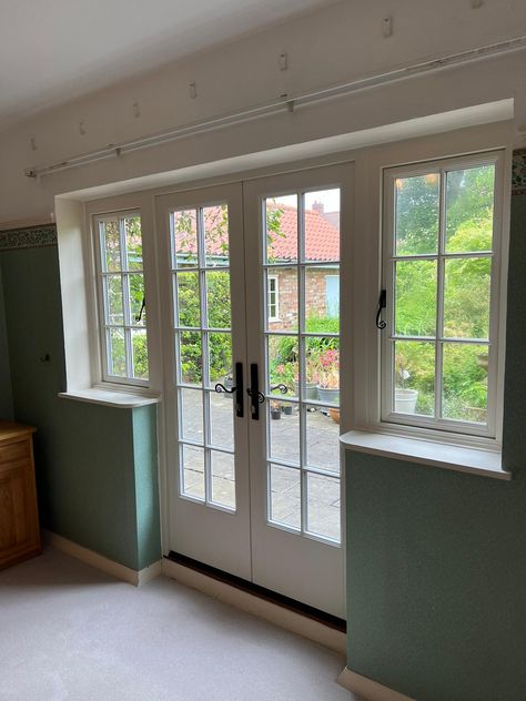 White french doors on the inside of a house with casement windows either side. Wooden French Windows, Georgian French Doors, Kitchen With French Doors To Patio, Door With Window Above, French Doors Farmhouse, Double Casement Windows, Sliding French Doors Patio, Single Patio Door, French Casement Windows